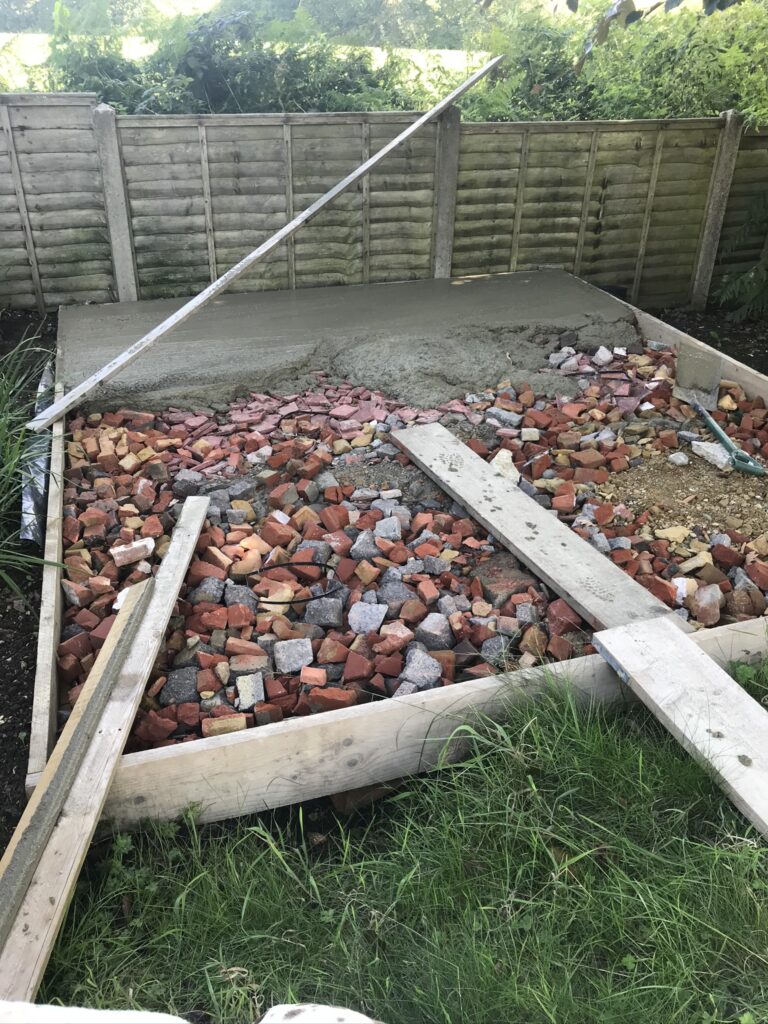 pouring concrete to create a small garden terrace