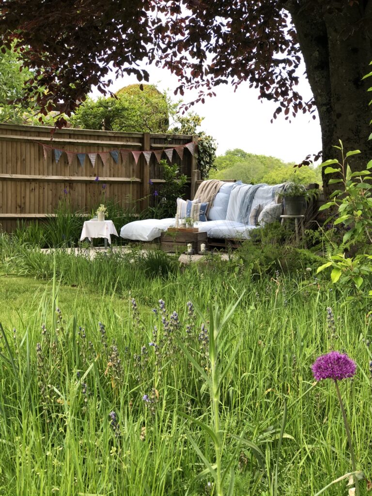 DIY wooden pallet sofa and cushions in summer garden