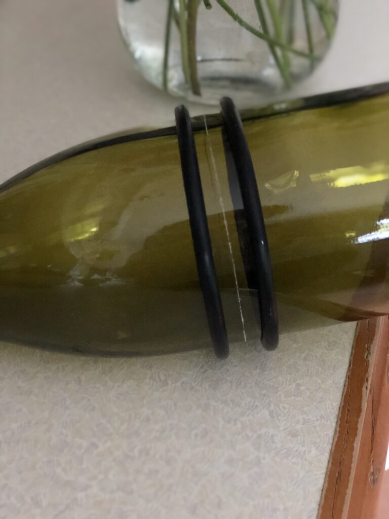 adding elastic bands either side of scored wine bottle