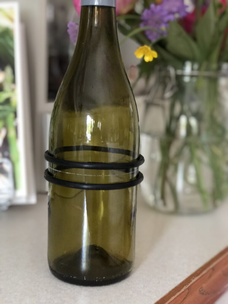 adding elastic bands either side of scored wine bottle