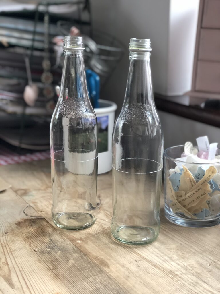 two clear glass bottles scored for cutting