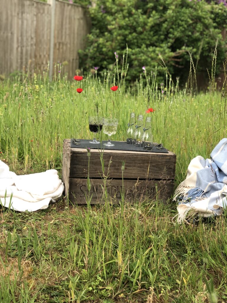 glass bottle decoration on wooden crate in wildflower meadow