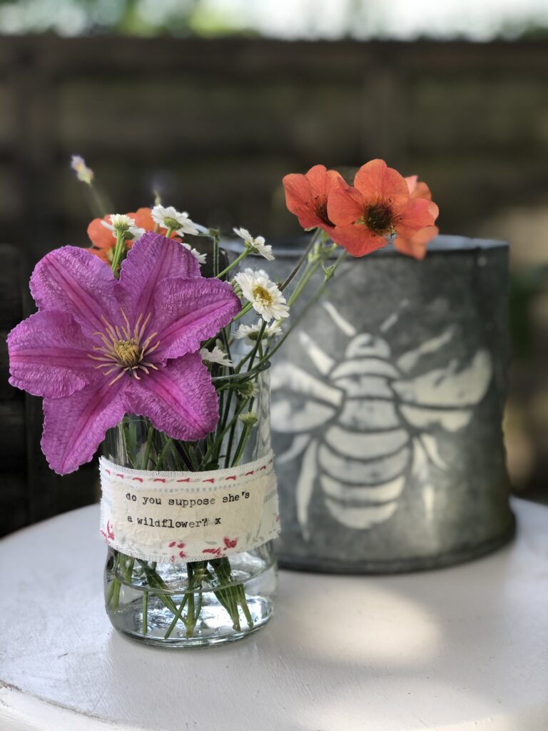 garden flowers in recycled glass jar with zinc stencilled jug and garden flowers