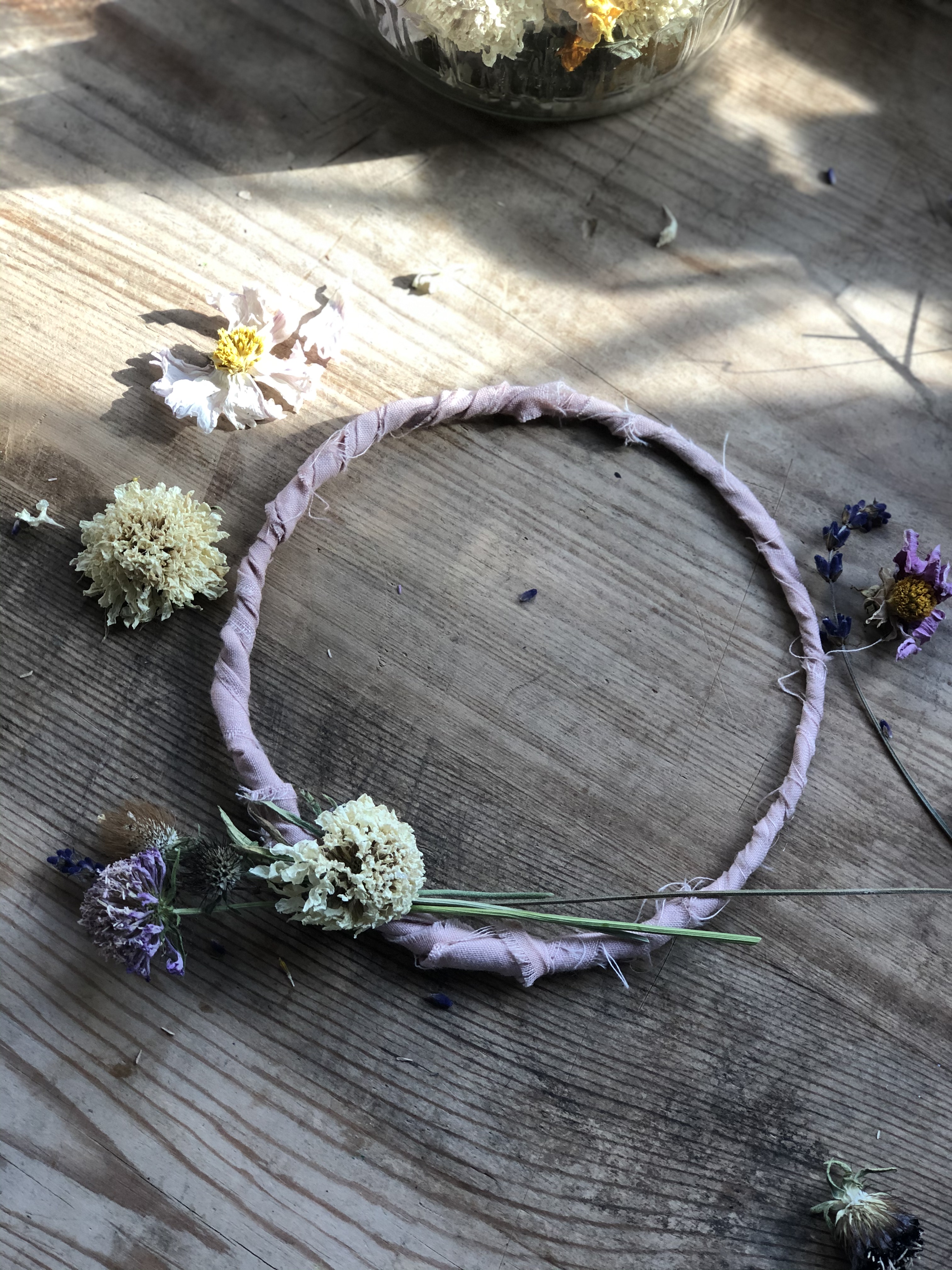 hot glueing dried flowers to rag ribbon