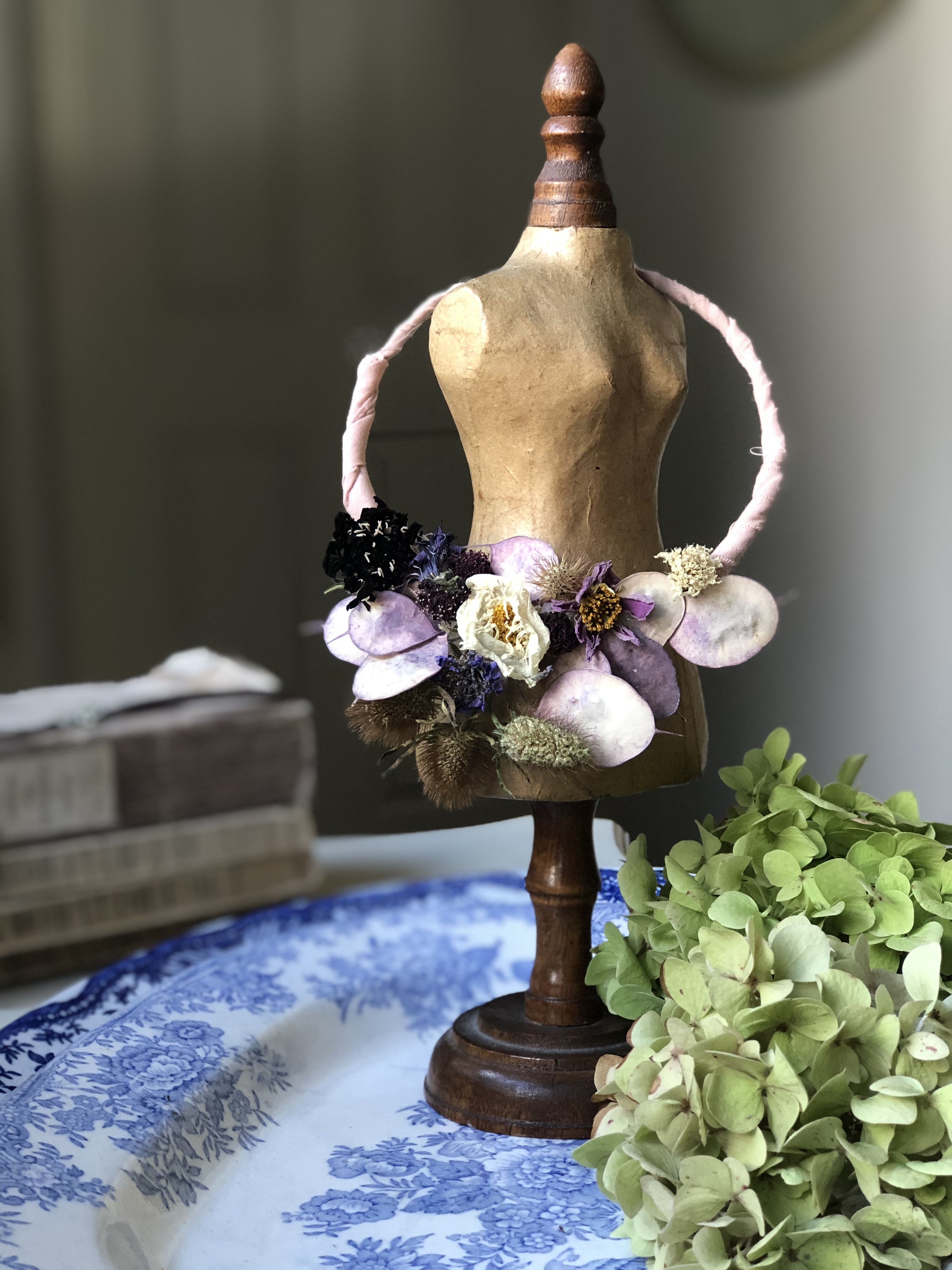 mini mannequin wearing dried flower wreath