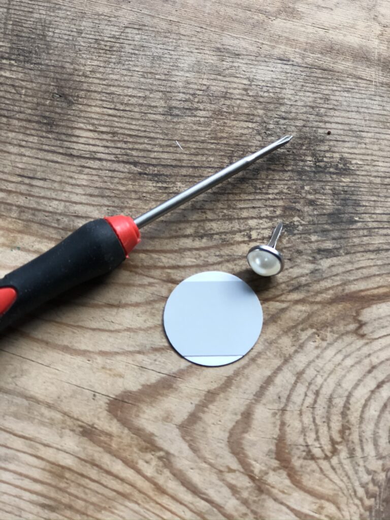 screwdriver, brad and paper circle