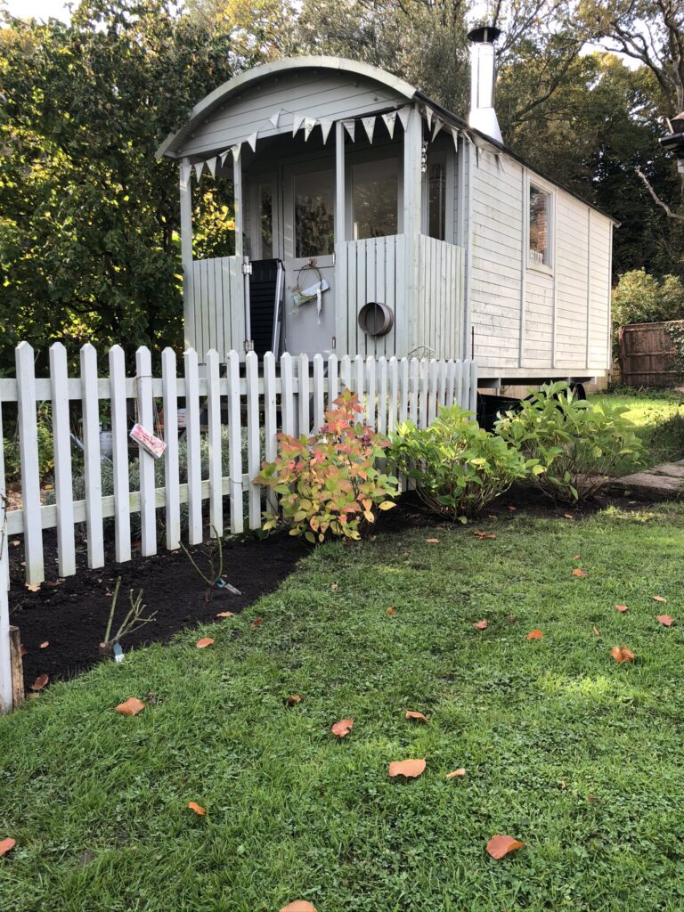 shepherds hut and picket fence in garden