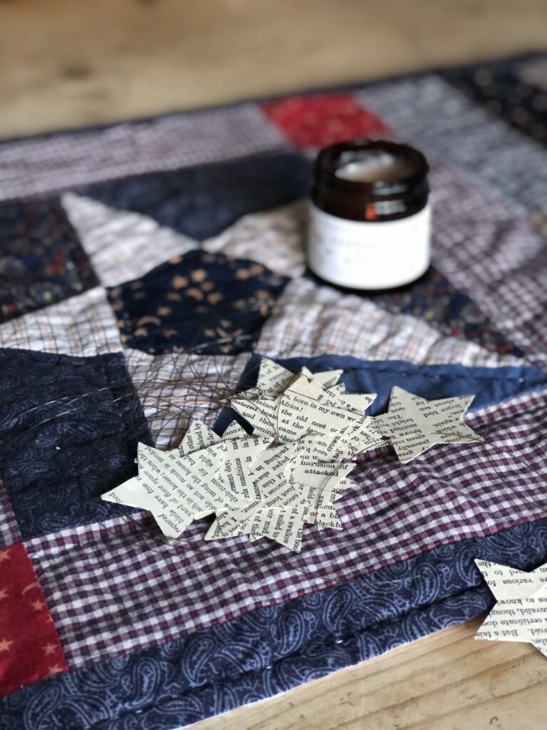 book paper stars and candle on pretty table runner