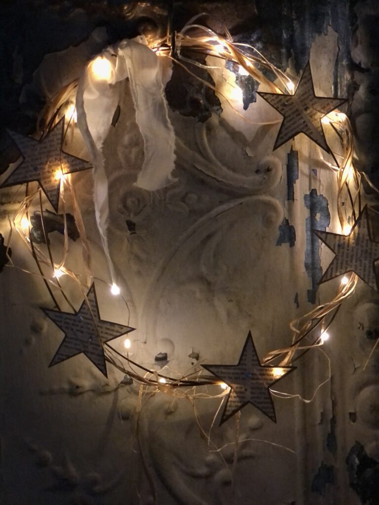 beautiful lit paper star and rusty wire wreath