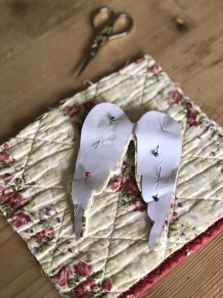 cutting out fabric wings from vintage quilt