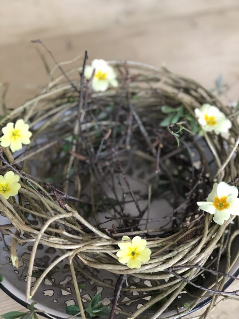 making a nest with twigs and primroses for a simple easter table decoration