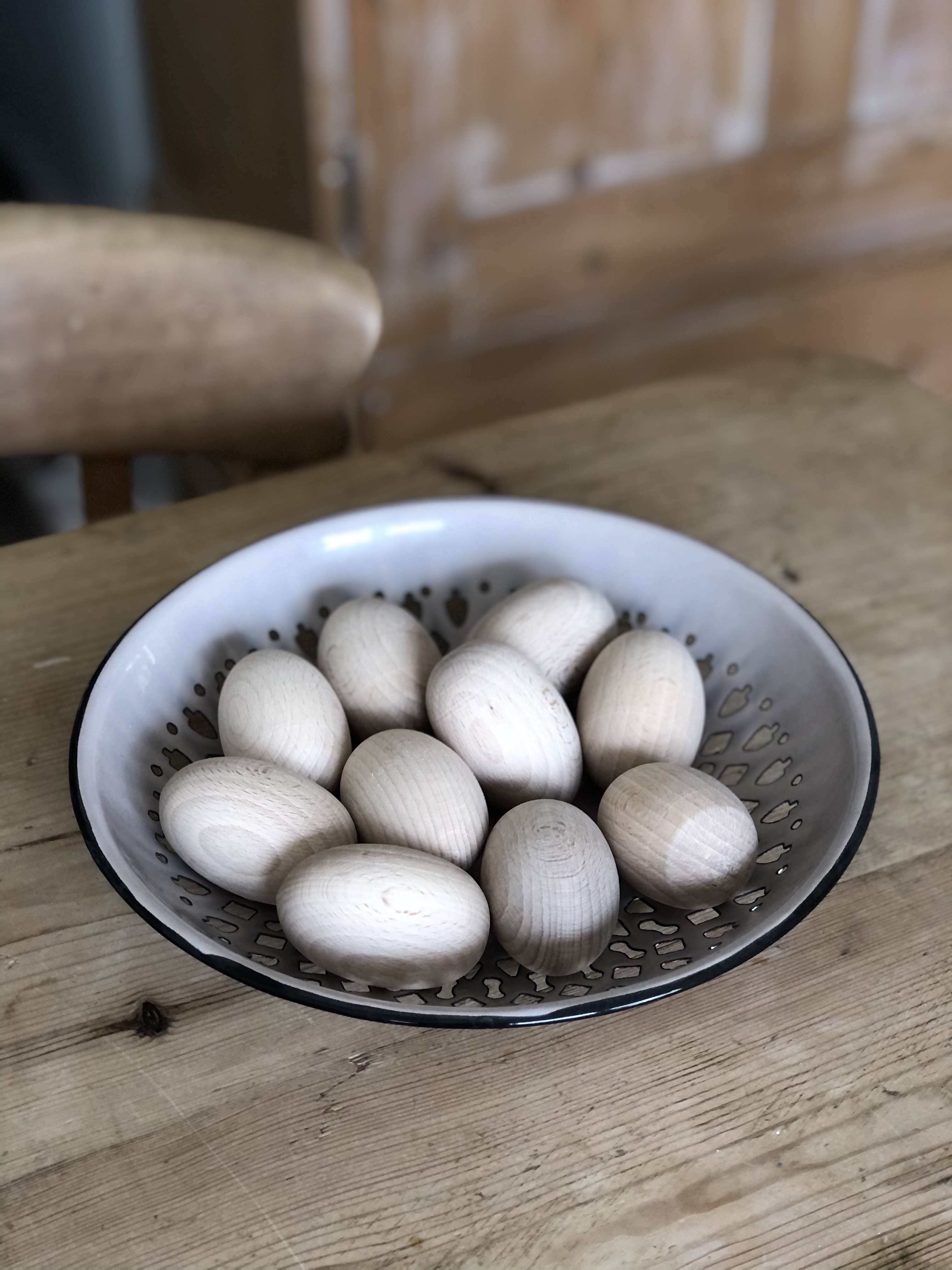 wooden craft eggs in bowl with painting equipment to create homemade easter table decoration