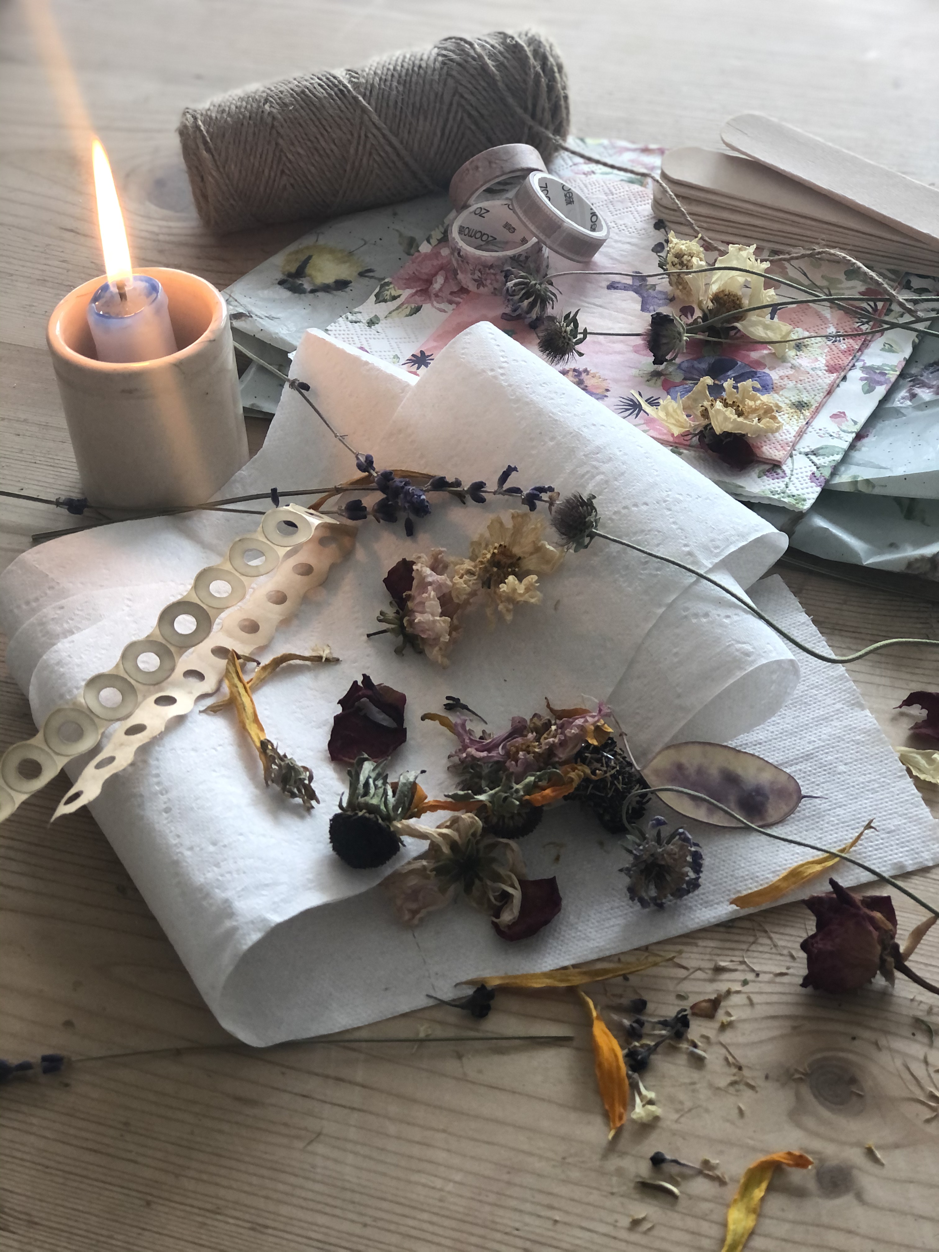 dried flowers, candle and papers