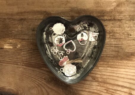 shiny trinkets and treasures in a vintage tin heart