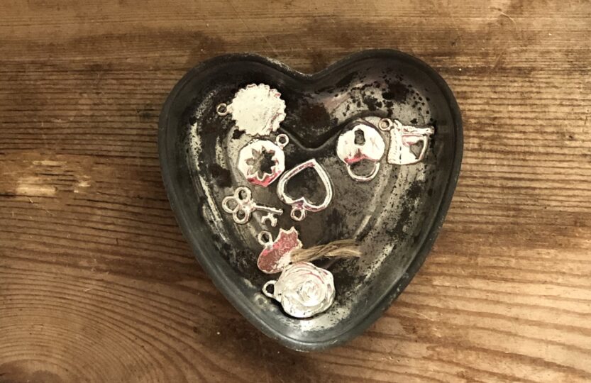 shiny trinkets and treasures in a vintage tin heart