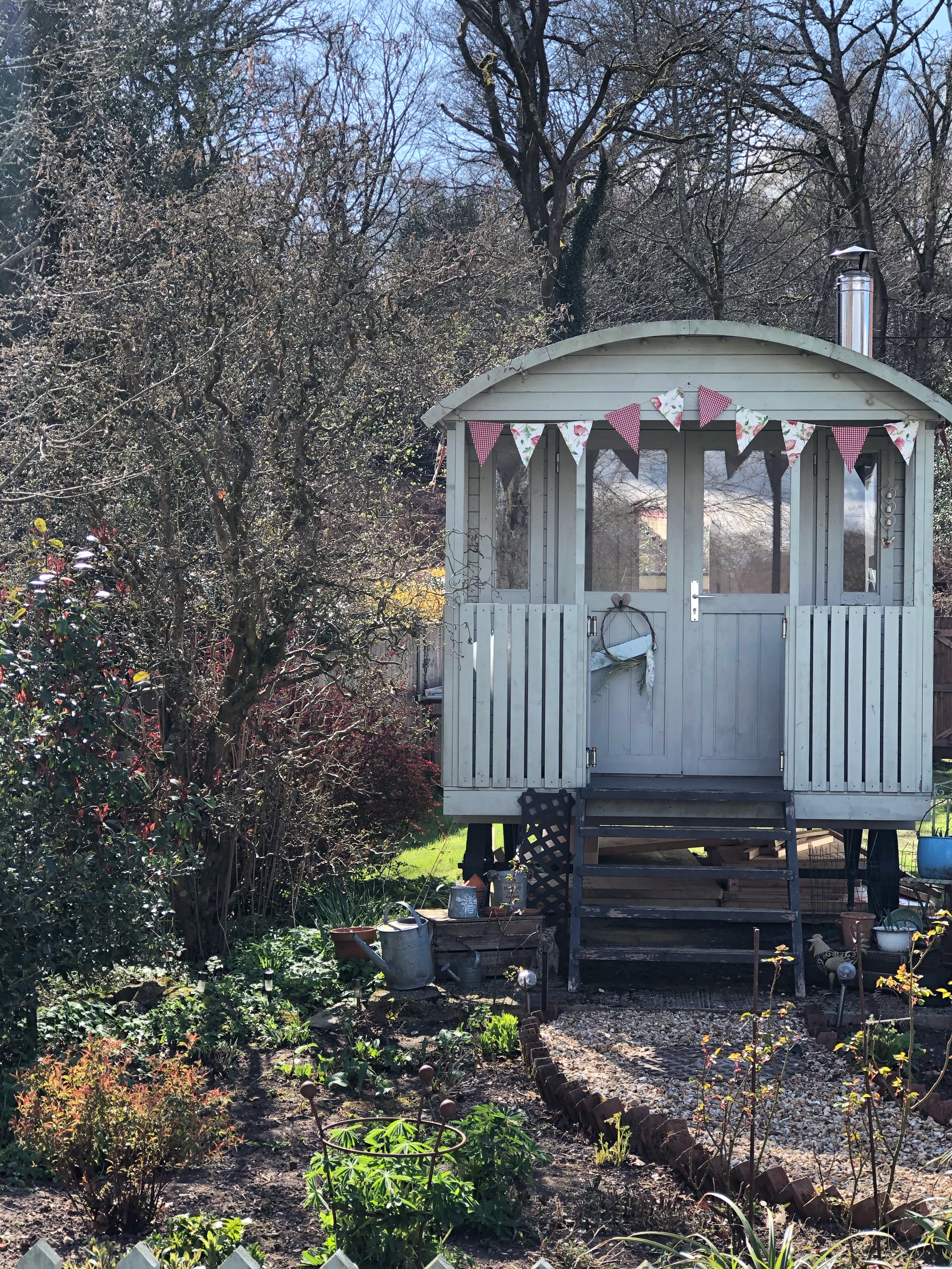 shepherds hut set in cottage garden