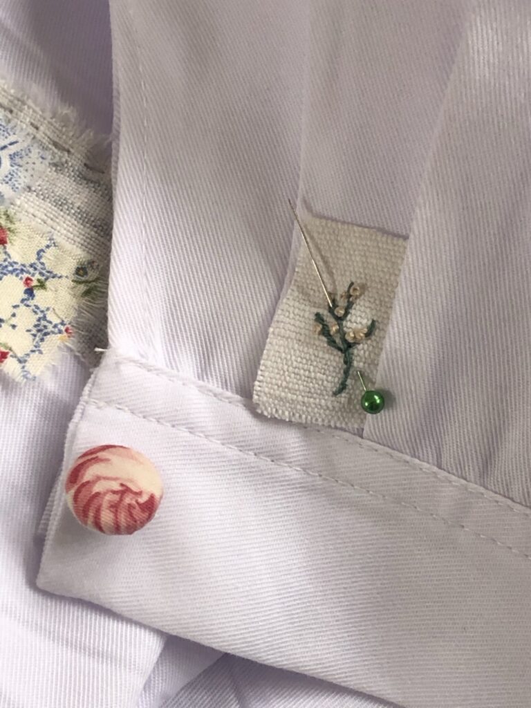 pink button and embroidery detail on bespoke art coveralls