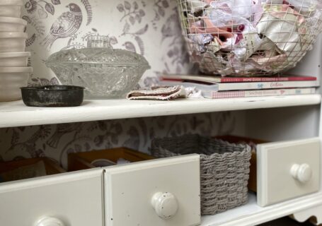 shelves full of drawers and baskets and fabrics in craft room