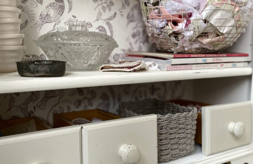 shelves full of drawers and baskets and fabrics in craft room