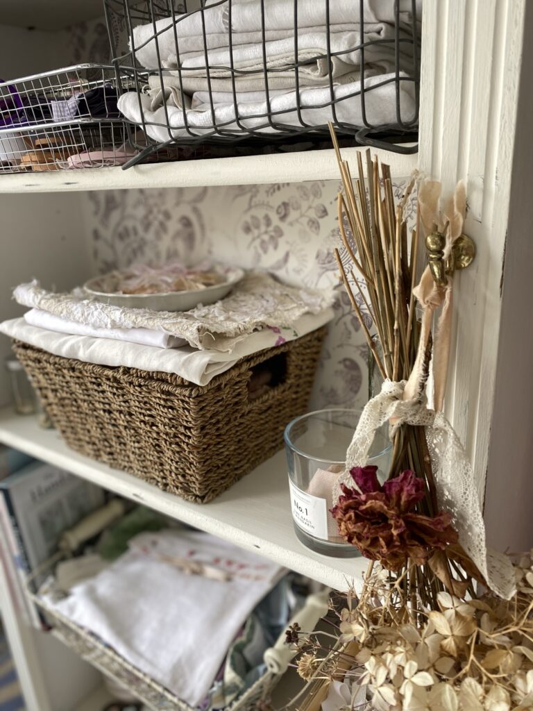 baskets and fabrics on the shelves of upcycled bookcase