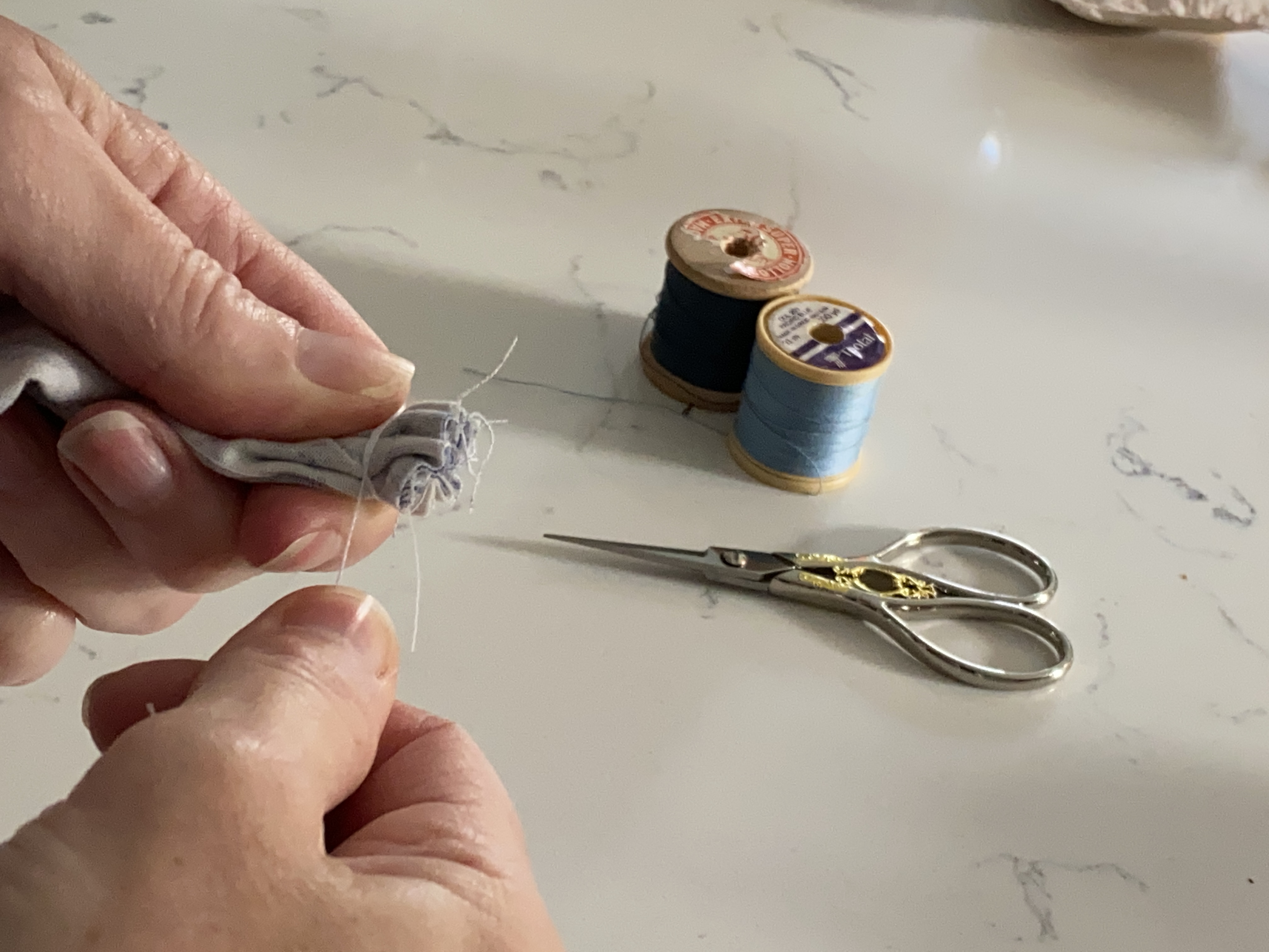 embroidery scissors, reels of vintage cotton and stitcher at work