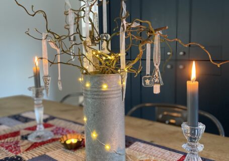 twig tree with fairy lights, candles and beautiful clear glass decorations on shaker style table runner