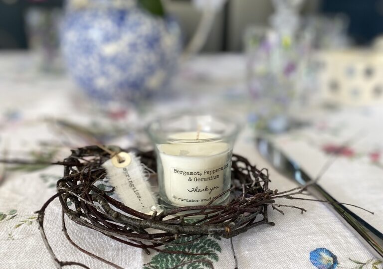 twig table place setting with tag and mini candle on flowery table cloth