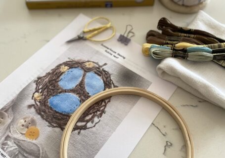 fabric paints, embroidery hoop, pattern, embroidery floss an pin cushion and fabric