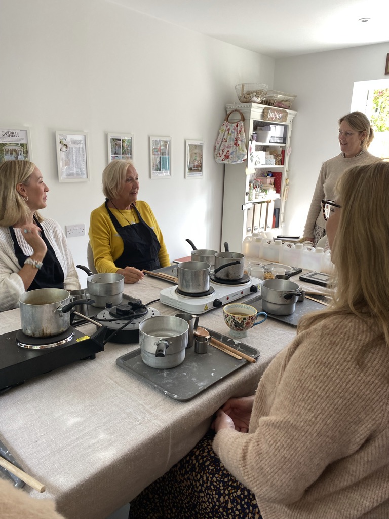 ladies gather with pans and tutor for candle making workshop