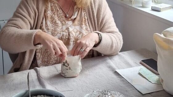 lady's hands hold open fabric pouch ready to fill to make fabric fruit