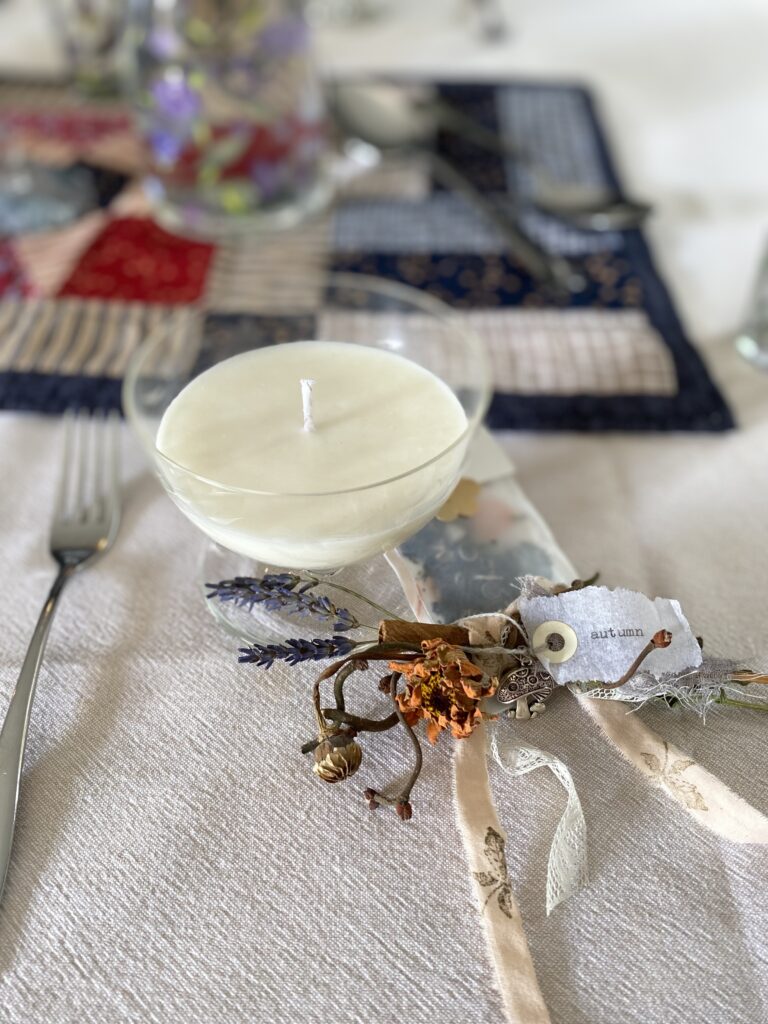 candle place setting on autumnal dining table