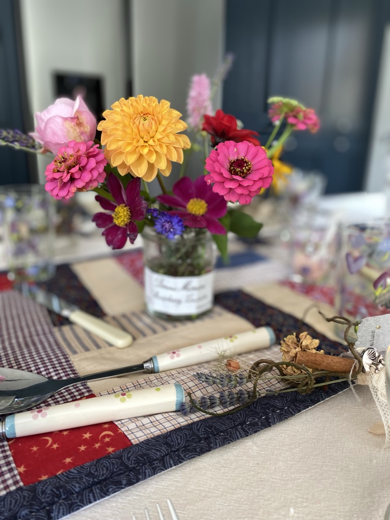 autumnal jam jar flowers on top of homespun colourful table runner