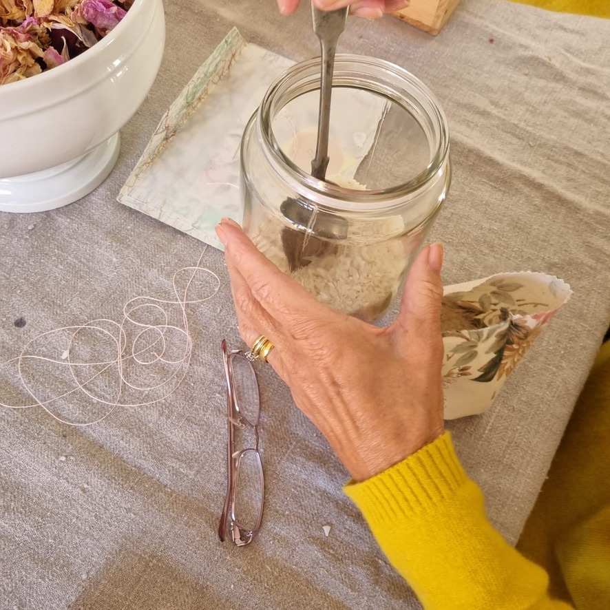 lady - hands only - mixes rice in glass jar taken from above