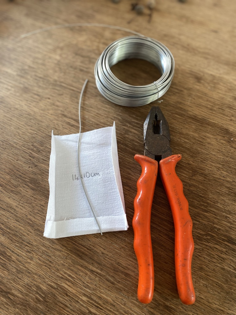 piece of white linen fabric roll of wire and red wire cutters