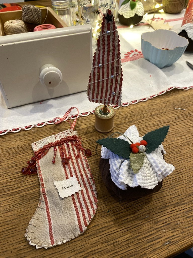 Christmas crafs, stocking, pudding and tree on craft table