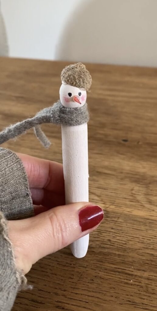 Gluing an acorn cup to a peg snowman