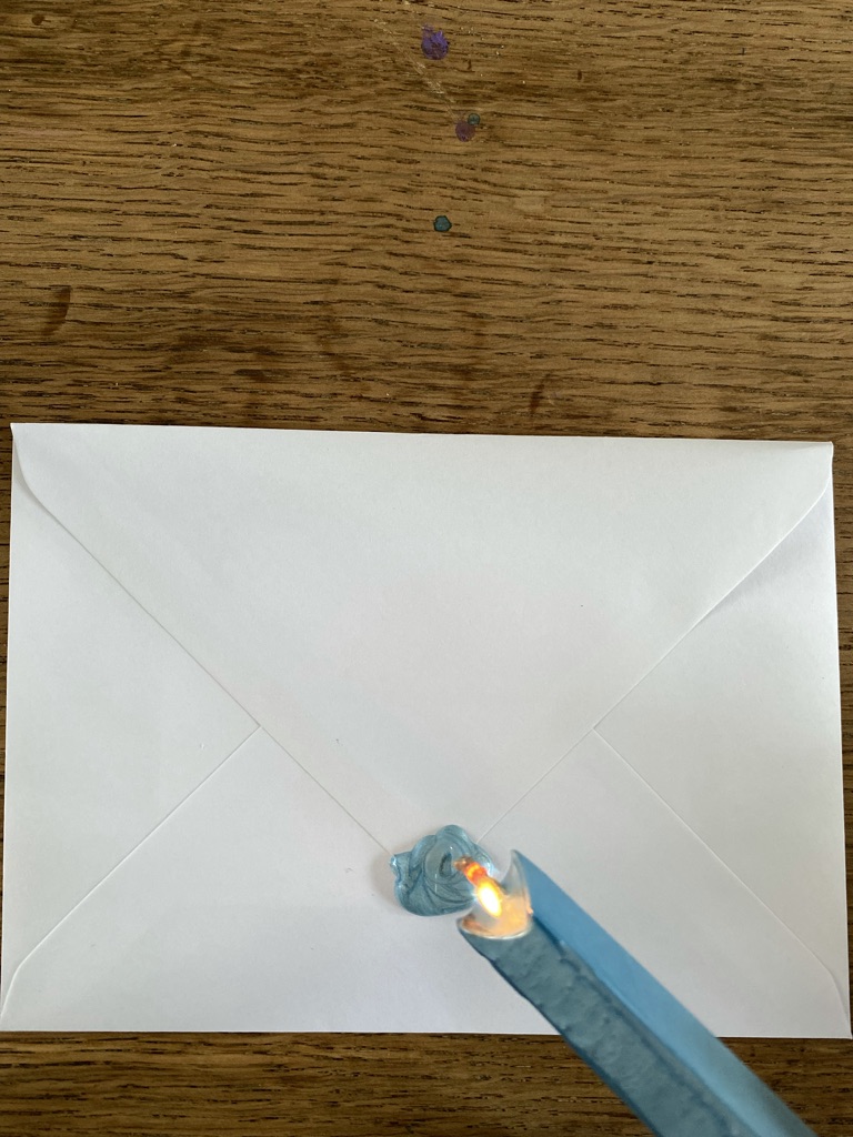 making a blue wax seal on an envelope