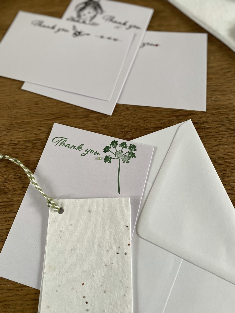 craft table with seed paper tags, envelope and thank you cards