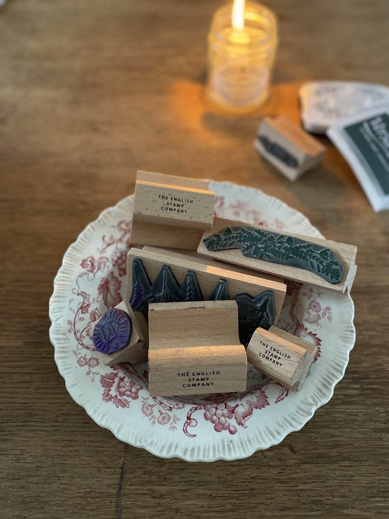 rubber stamps in a vintage bowl with candle in background