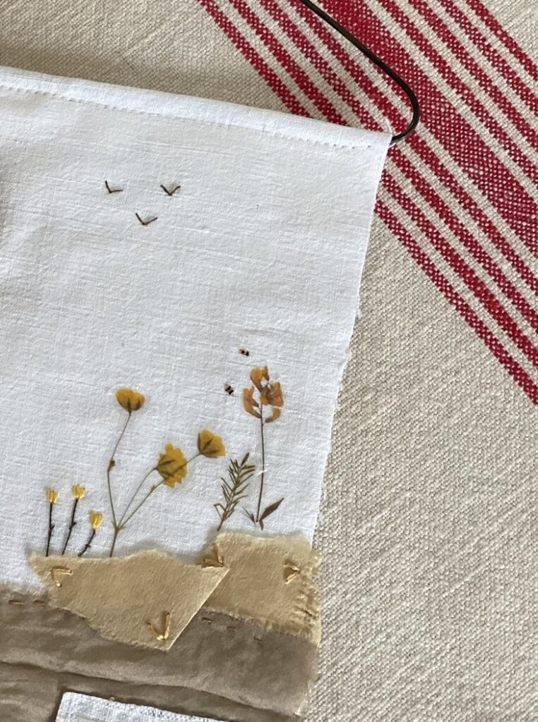 embroidered birds, flower sticker, tiny embroidered bees and paper and ribbon making a fabric collage