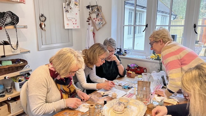 three ladies in a craft room working on a mixed media fabric collage