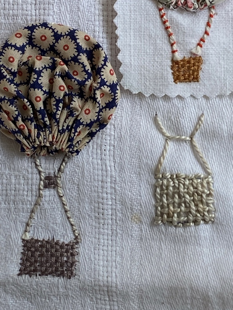 suffolk puff makes a hot air balloon with embroidered basket and other baskets in background