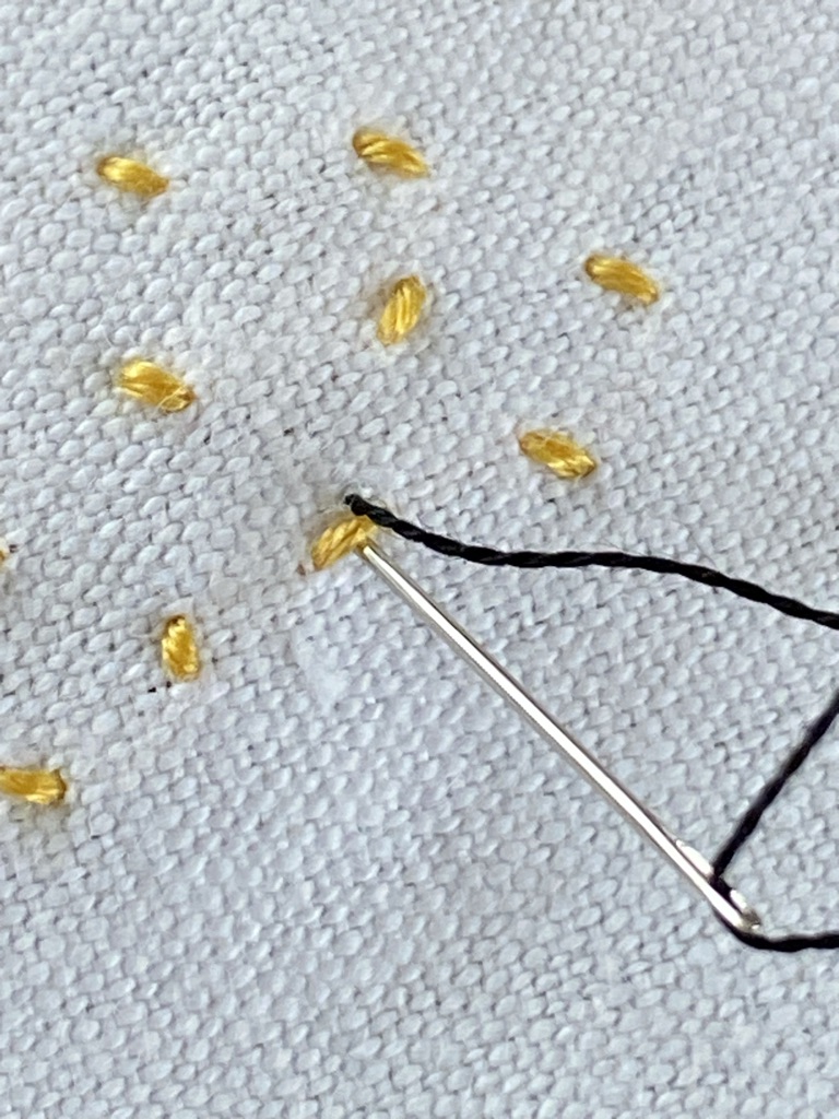 yellow stab stitches form the body of bumble bees whilst black thread is also applied